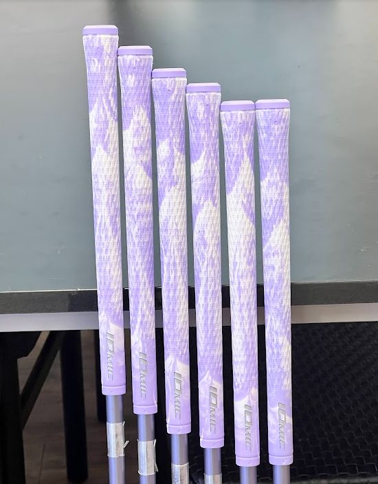 엘라스토머 그립 예시: 보라색과 흰색 무늬의 이오믹 그립 여섯 개를 클럽에 끼워 세워 둔 모습